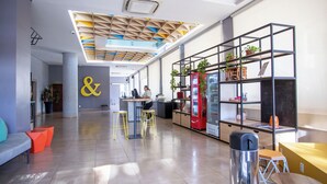 A modern interior with a central desk, seating areas, and a vending machine. - B&B Hotels Uberlândia (Uberlandia)