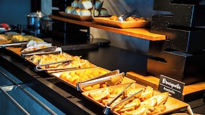 A buffet with various food items, including bread and pastries, and a sign indicating 'Bruschetta'. - B&B Hotels Uberlândia (Uberlandia)