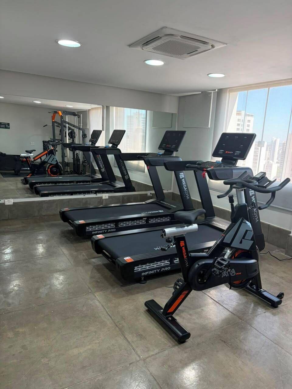 A gym with treadmills, stationary bikes, and exercise equipment.