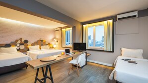 A hotel room with two beds, a desk with a laptop, a chair, and a TV. - B&B Hotels Uberlândia (Uberlandia)