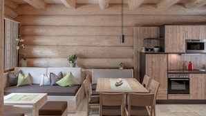 Ein modernes Blockhaus-Interieur mit Essbereich, Küche und Sitzgelegenheit.