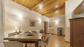 Un comedor con una mesa y sillas de madera, una lámpara y un cuadro en la pared.