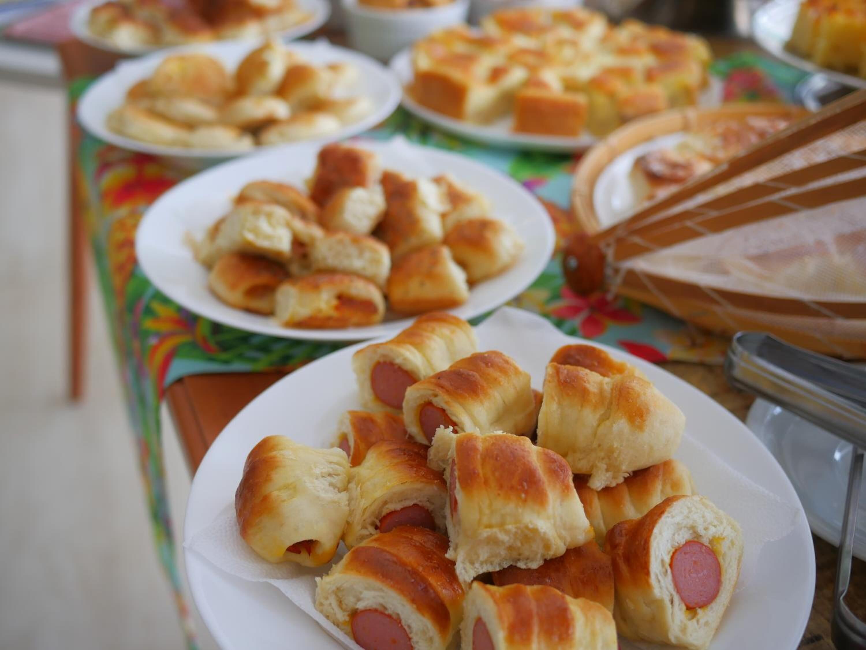 A table with plates of hot dogs in buns.