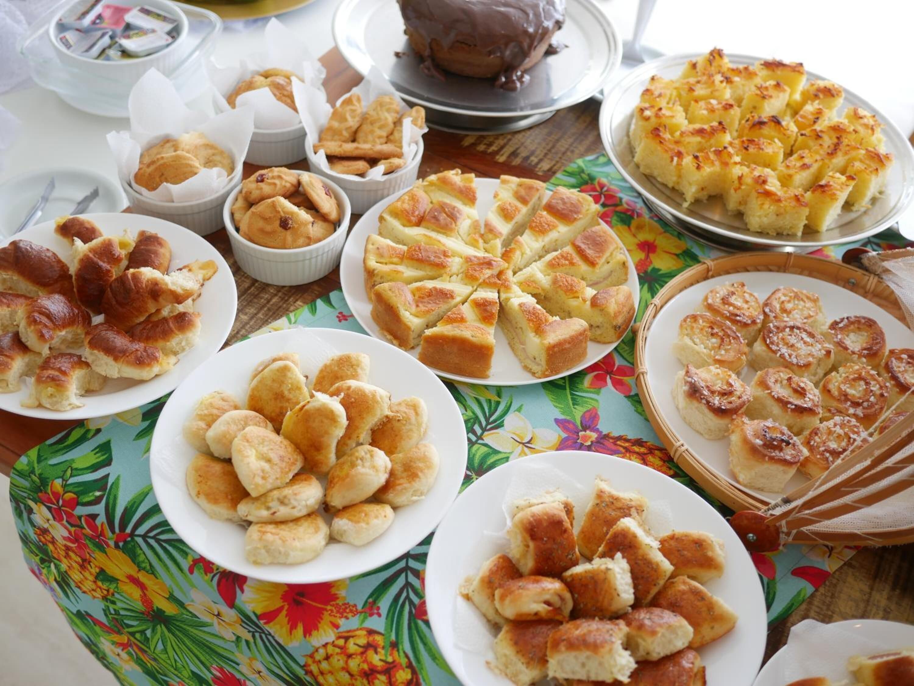 A table with various baked goods including bread rolls, a pie, and pastries.