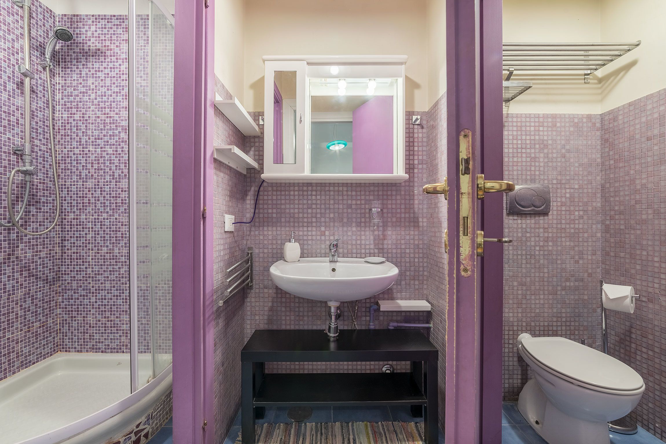 A bathroom with a shower, sink, and toilet.
