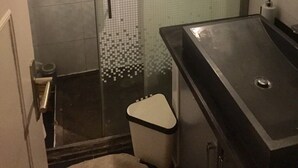 Une salle de bain avec une douche à parois de verre, un lavabo et des toilettes.