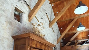 A rustic interior with a wooden table and chairs, a stone wall, and a staircase leading to an upper level. - Cottage 8 ps. 3 cbres. Swimming pool. Center Drôme, ideal for discovering Drome and Ardéche (Grane)