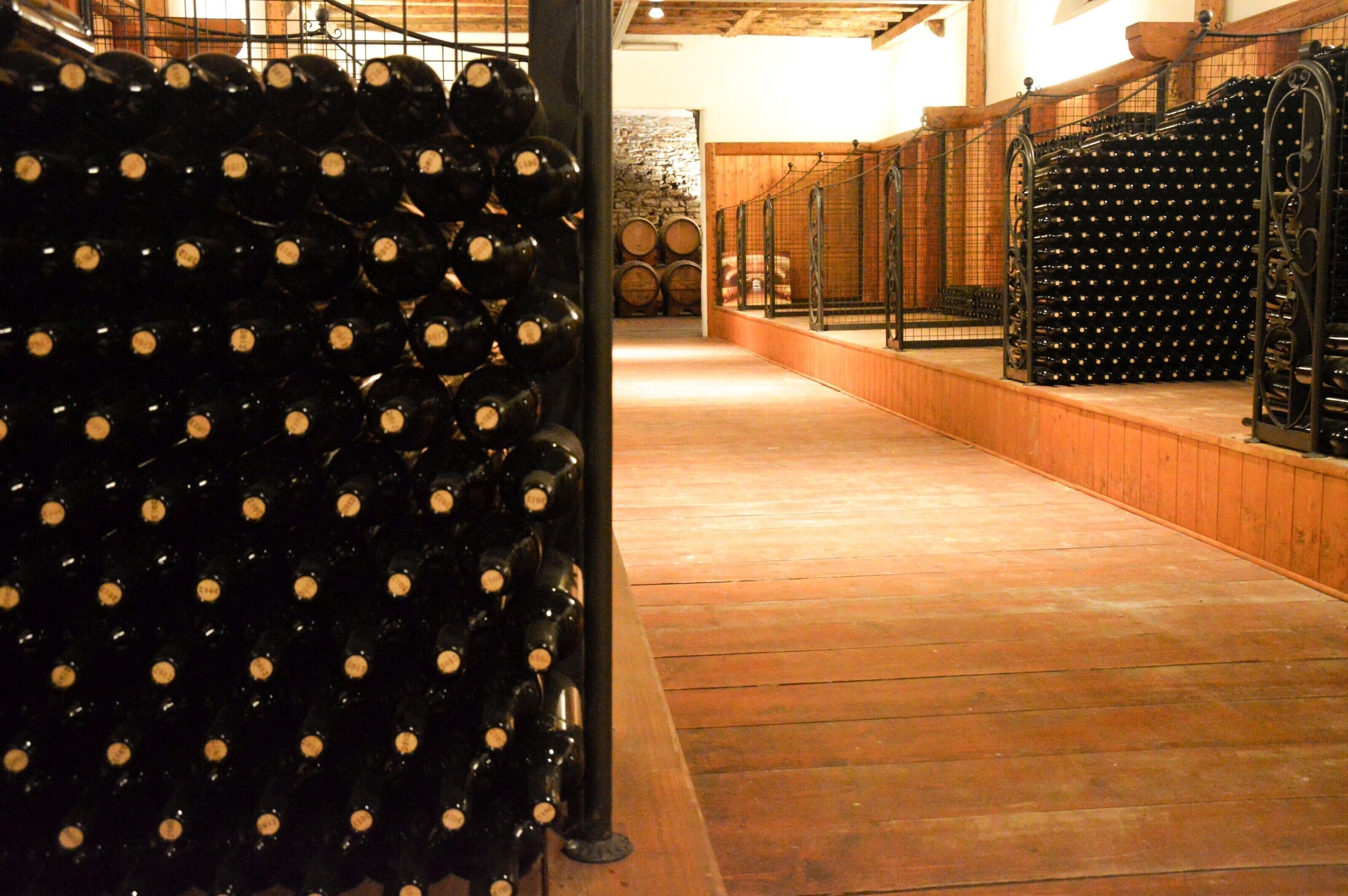A wine cellar with rows of wine bottles and barrels.