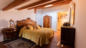 A bedroom with a wooden bed, a nightstand, a dresser, and a large rug.