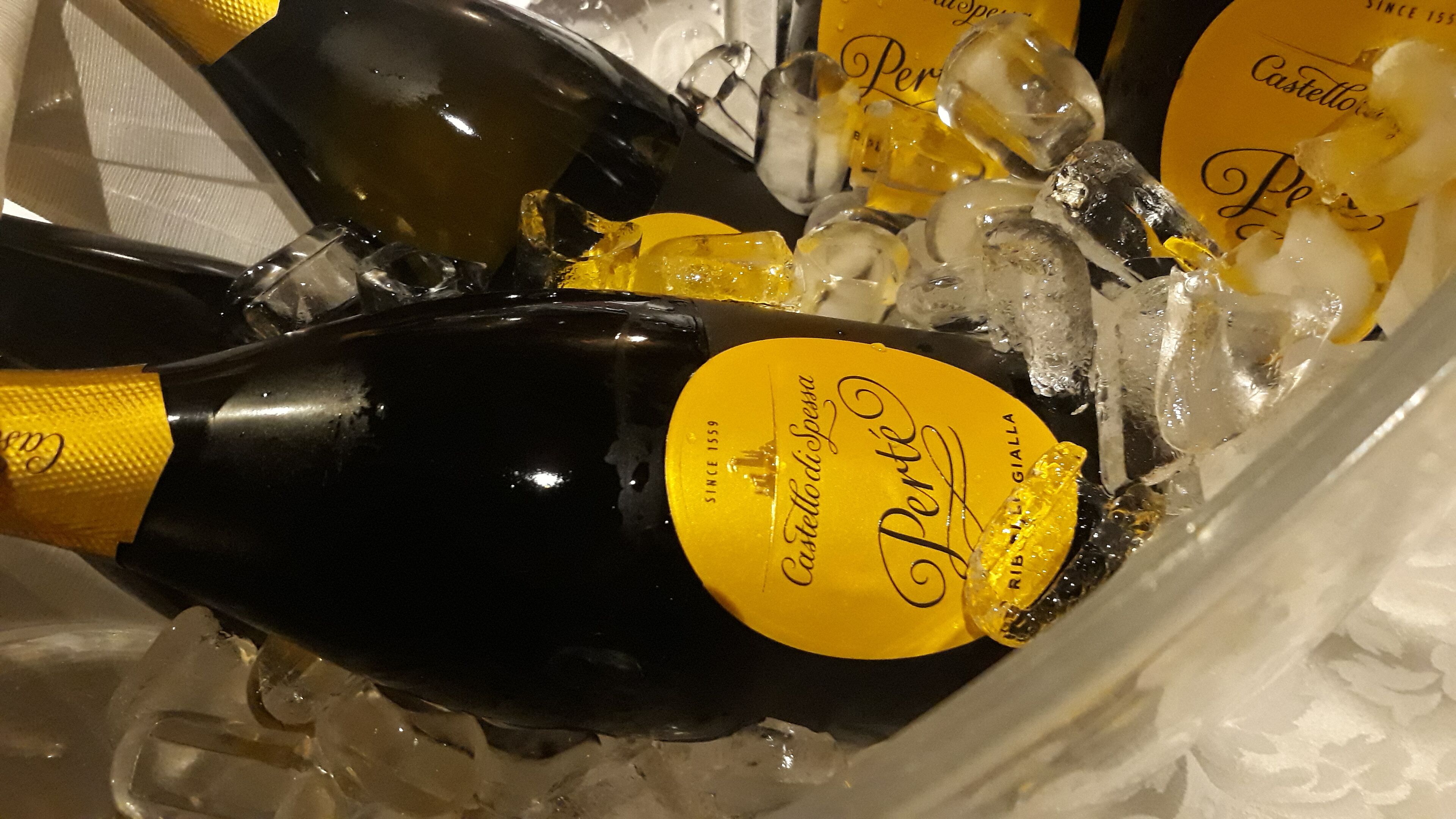 Une bouteille de vin Castello di Spesa Perche dans un récipient rempli de glaçons.