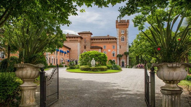 A historic building with a central courtyard, a statue, and a gate.