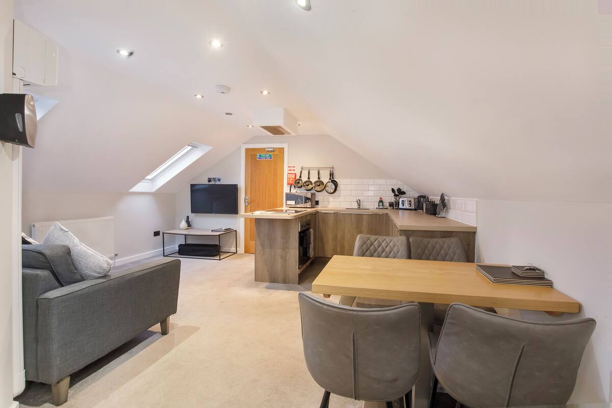 Un moderno apartamento tipo loft con comedor, kitchenette y una zona de estar acogedora.