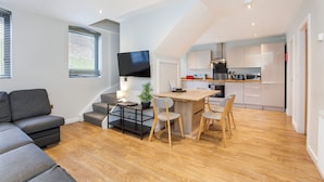 A modern apartment with a living room, dining area, kitchen, and a staircase. - City Apartments Monkbar Mews (York)