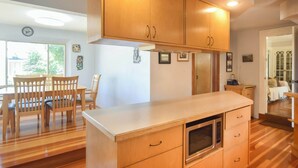 Une cuisine avec des meubles de rangement en bois, un plan de travail et un four à micro-ondes.