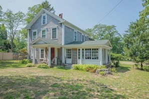 A two-story house with a porch, a covered front porch area, and a well-maintained lawn.