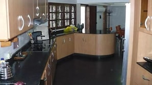 Una cocina con armarios de madera, encimera negra y distribución curva.