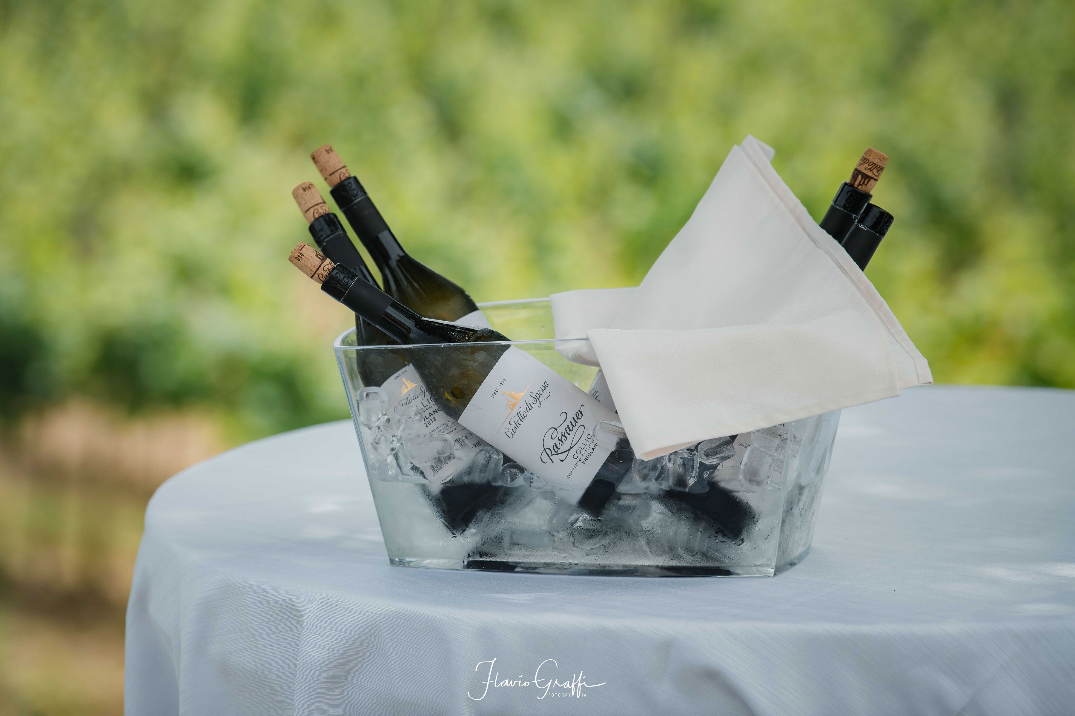 A glass container with bottles and a napkin on a table.