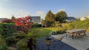 A garden with a wooden deck, a fire pit, and outdoor furniture. - House 200m from the sea in BENODET - 4 bedrooms: all on foot! (Bénodet)