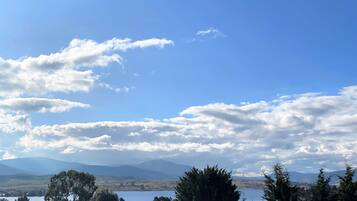 A landscape with a lake, mountains, and trees.