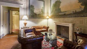 Un salón lujoso con un sofá de cuero, una mesa de centro de vidrio y una chimenea.