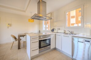 A modern kitchen with white cabinetry, a built-in oven, a microwave, and a dishwasher.