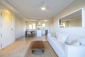 A modern living room with a sofa, coffee table, and dining area.