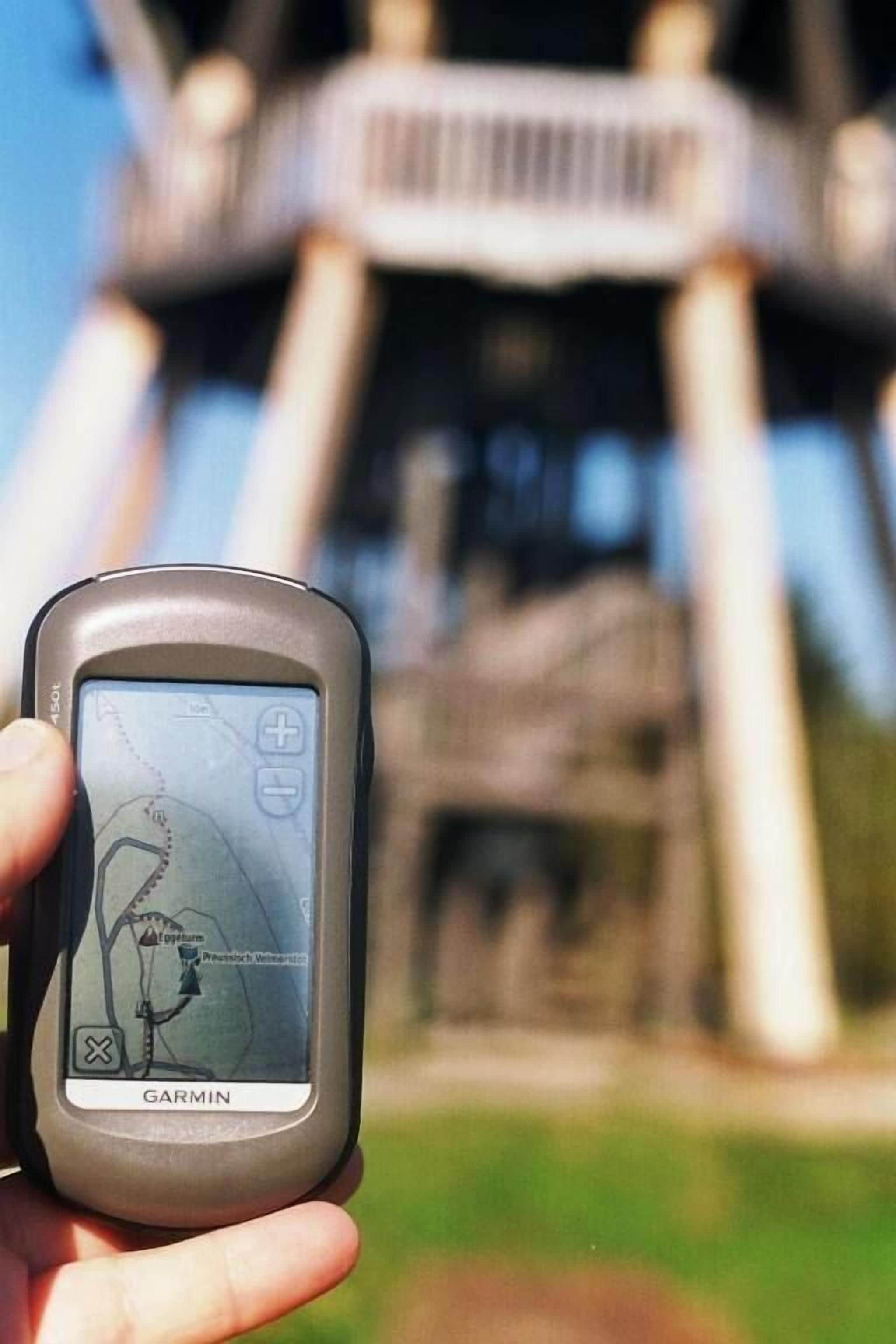 Ein Garmin GPS-Gerät vor einem Gebäude mit modernem Architekturstil.