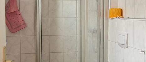 Ein Badezimmer mit Duschkabine, Toilette und Waschbecken.
