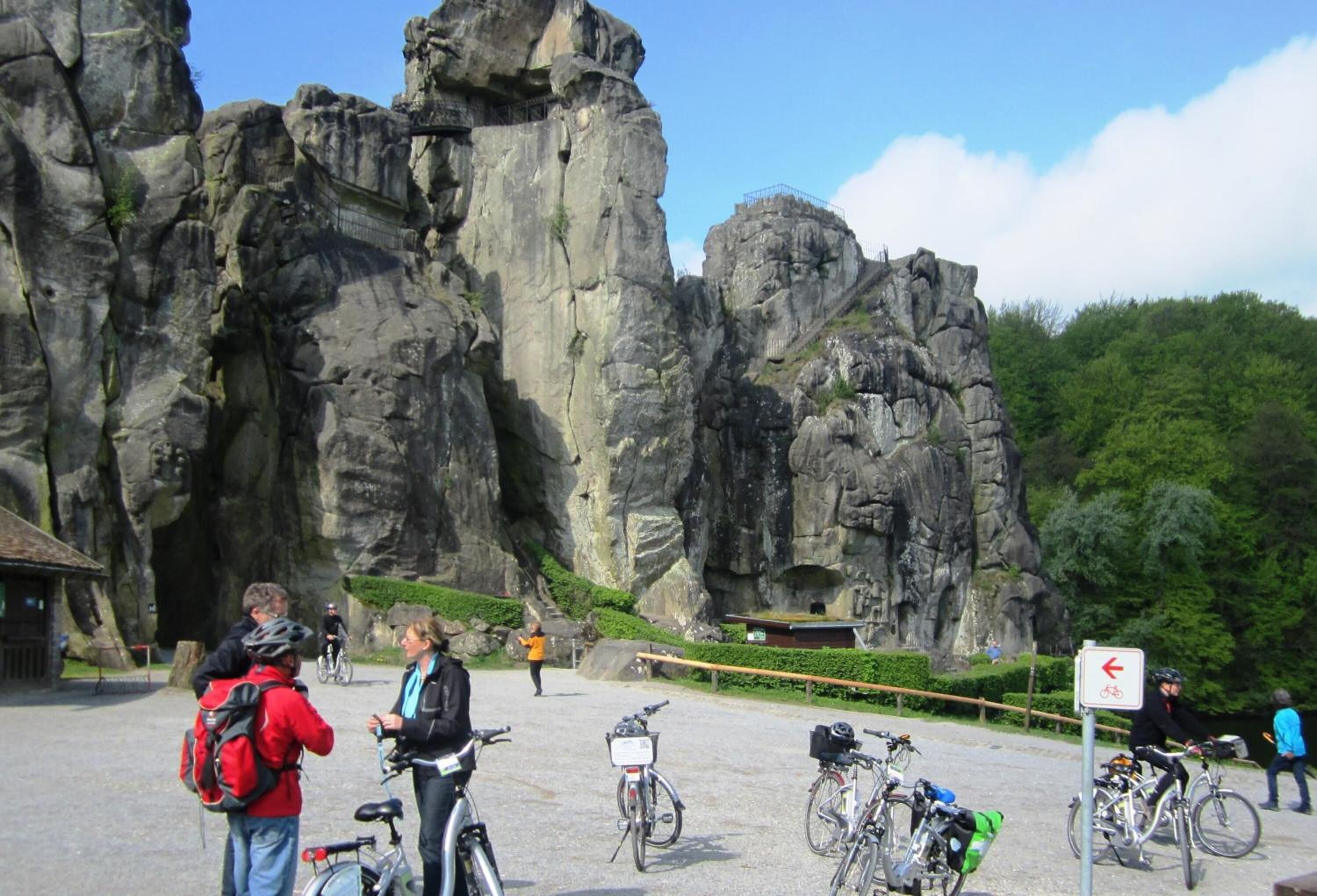 A rocky outdoor area with bicycles and people.
