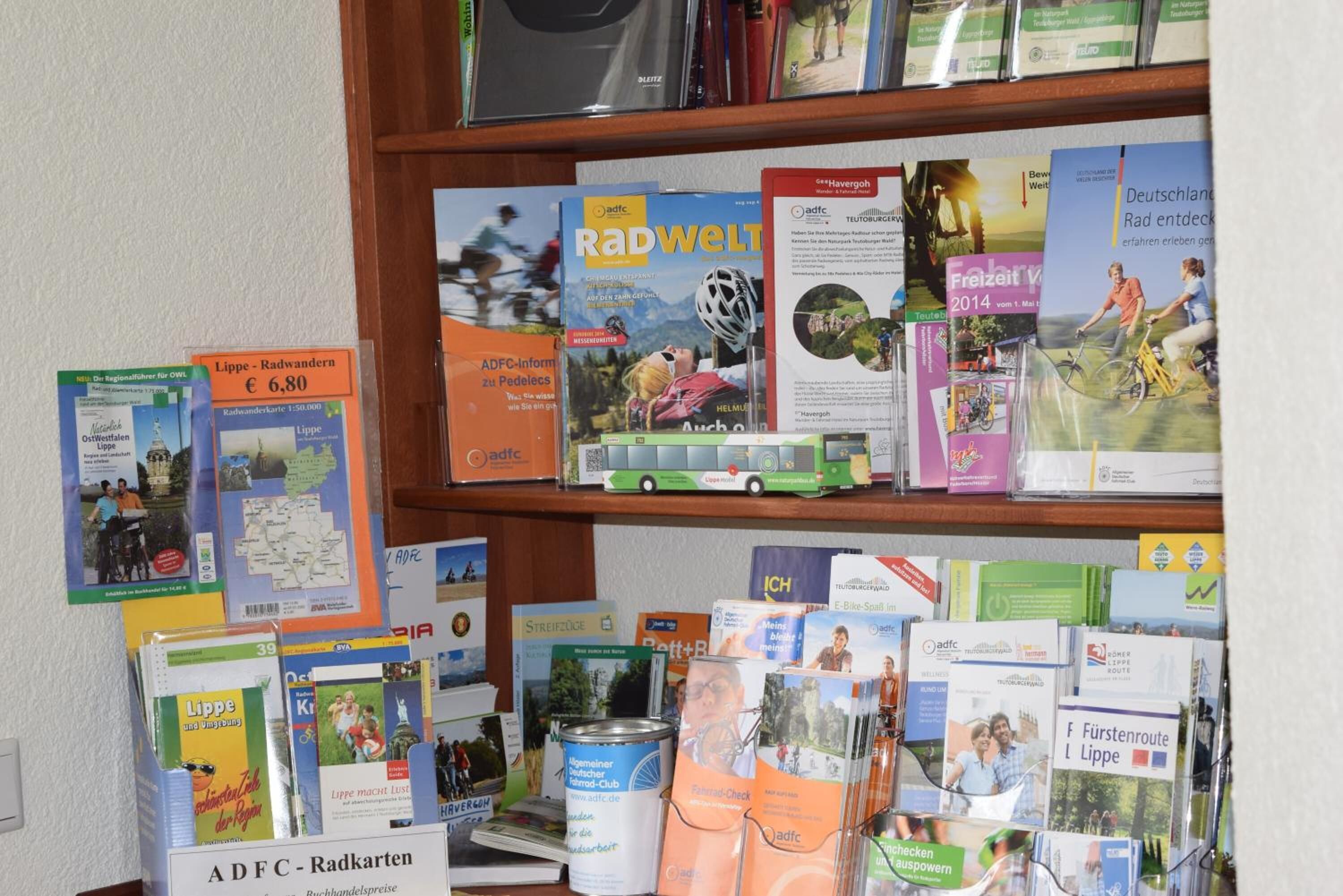 Una colección de folletos y mapas de viaje sobre una estantería.
