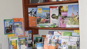 Una colección de folletos y mapas de viaje sobre una estantería.