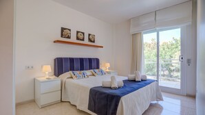 A bedroom with a bed, nightstands, and a window with a view. - Family friendly apartment with pool, close to all amenities and the Pinewalk.  (Pollensa)