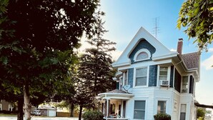A two-story house with a porch, a garage, and a well-maintained lawn.
