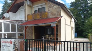 A two-story building with a stone facade, a red-tiled roof, and a gated entrance. - A whole holiday house with a garden in Fonyód for 2-10 persons (Fonyód)
