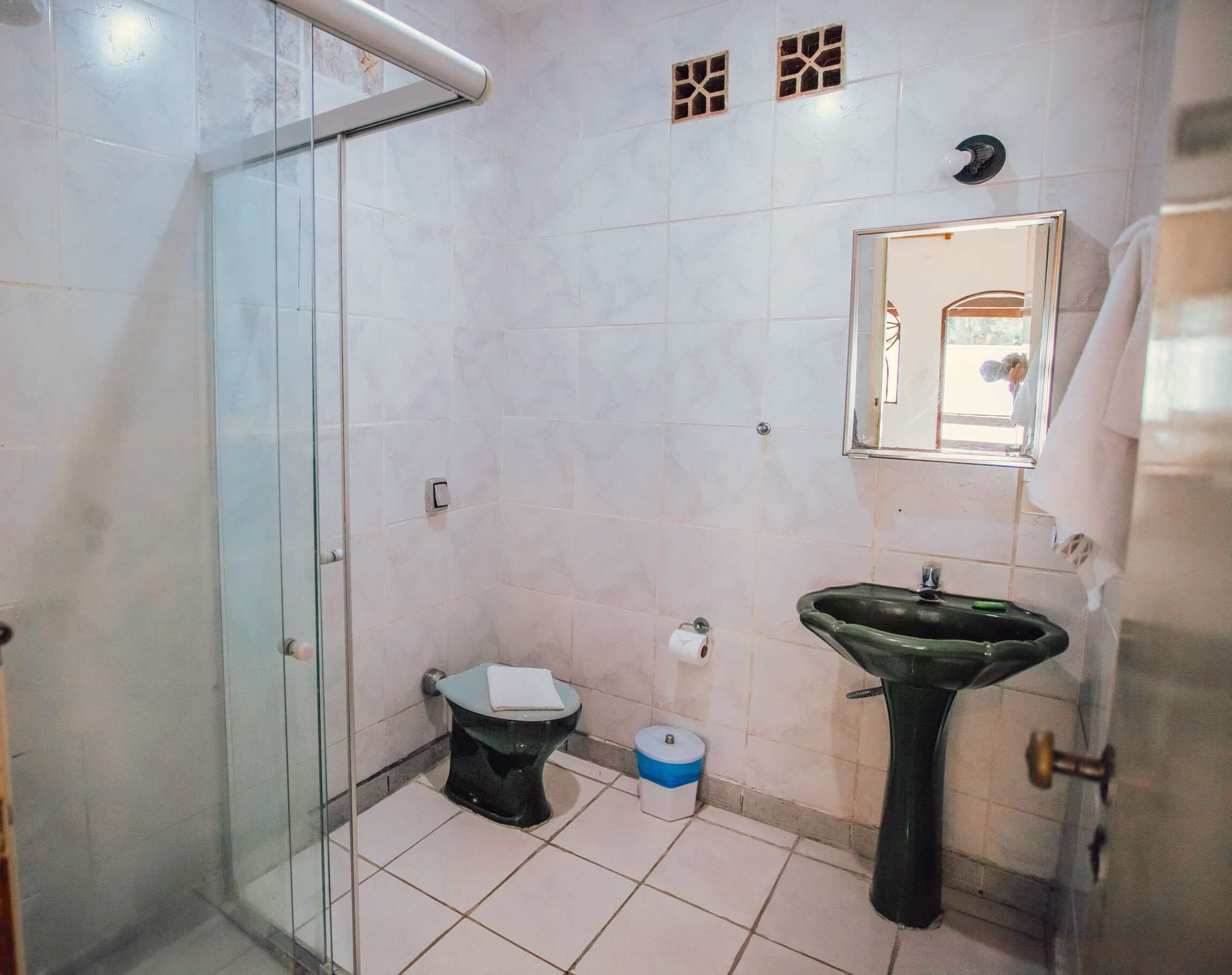 Un baño con cabina de ducha de vidrio, inodoro, lavabo y espejo.