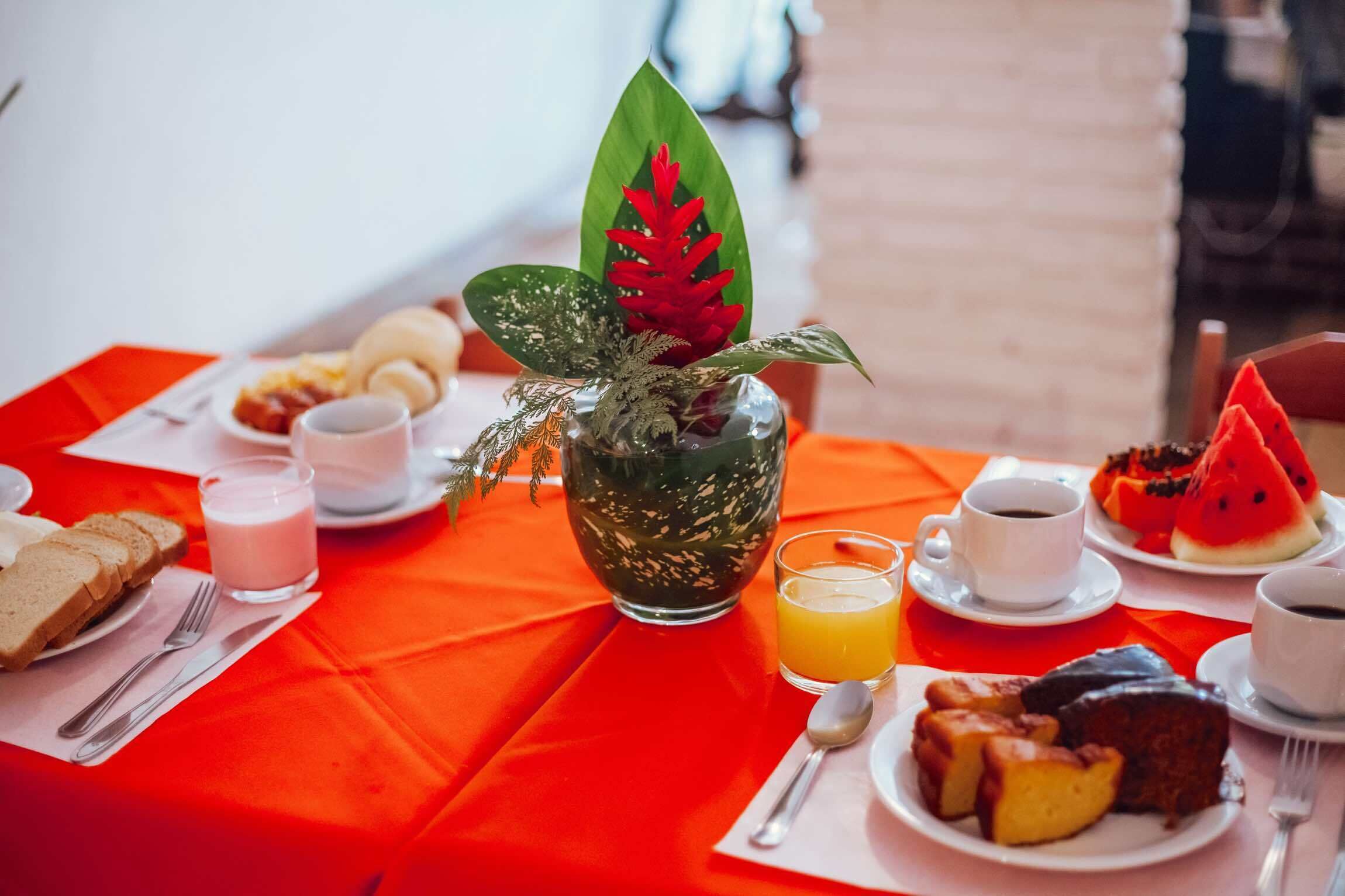 A breakfast table with various food items, including toast, fruit, and beverages.