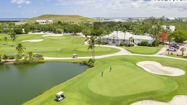 A golf course with sand bunkers, a pond, and a clubhouse. - Key West - Stock Island  (Key West)