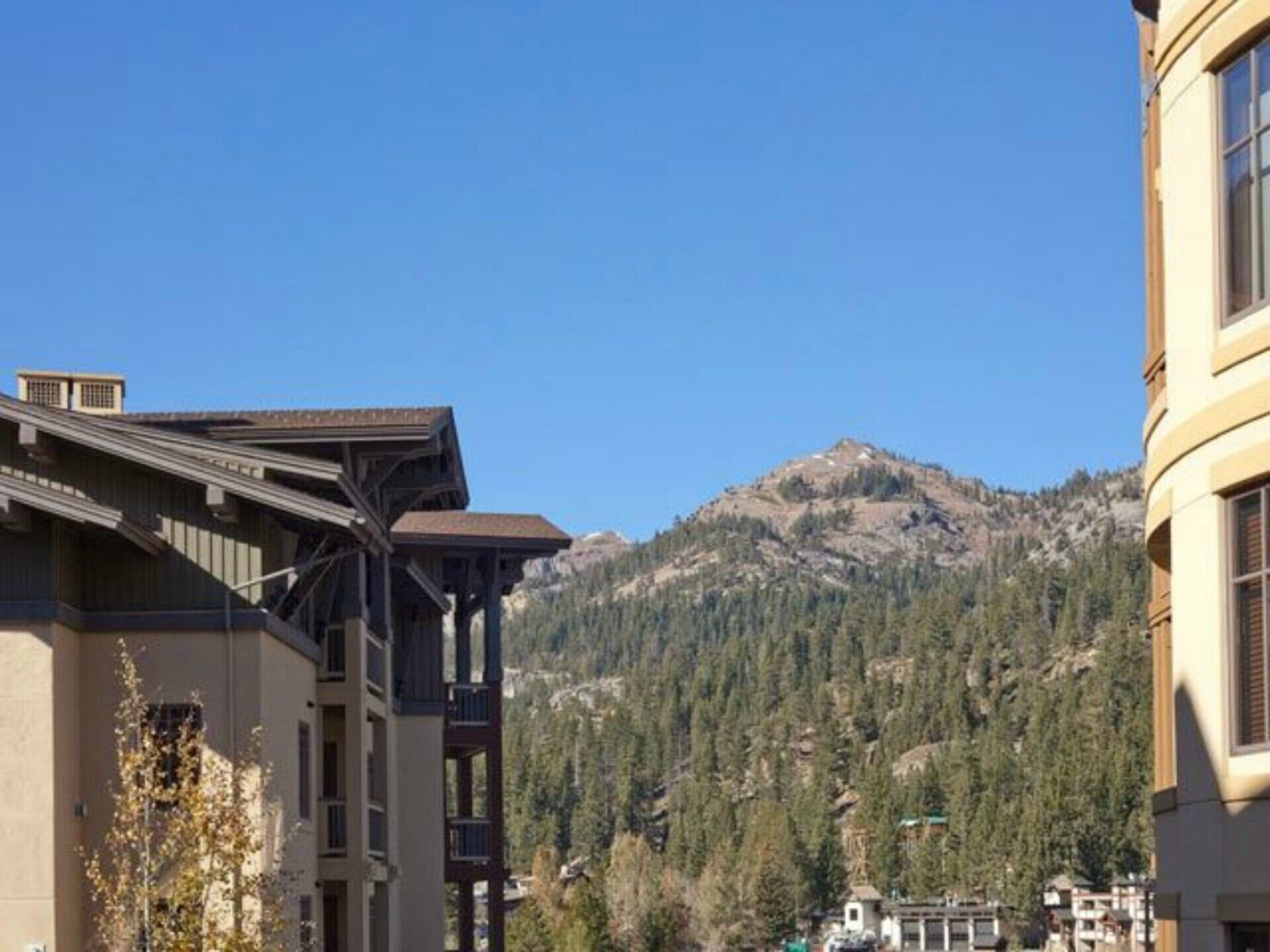 A building with a balcony and a mountain in the background.