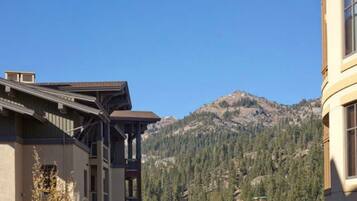 A building with a balcony and a mountain in the background.