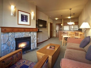 Cozy living area with a fireplace, flat-screen TV, and comfortable seating.