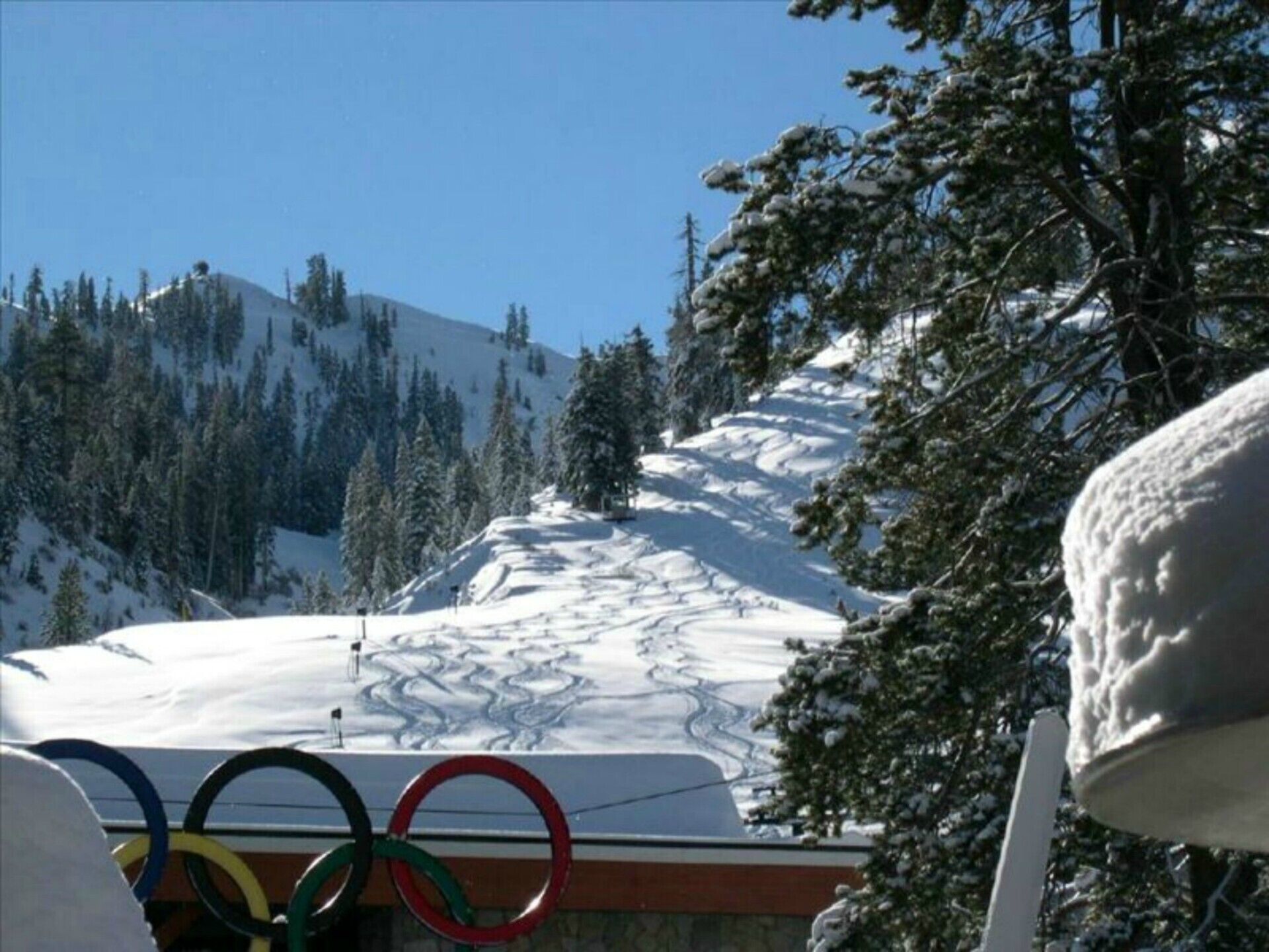 A snowy mountain landscape with Olympic rings in the foreground.