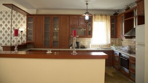 Une cuisine avec des meubles en bois, un îlot central et un lustre.