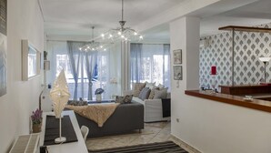 Un salon moderne comprenant un canapé, un coin repas avec une table et un espace cuisine avec un comptoir.