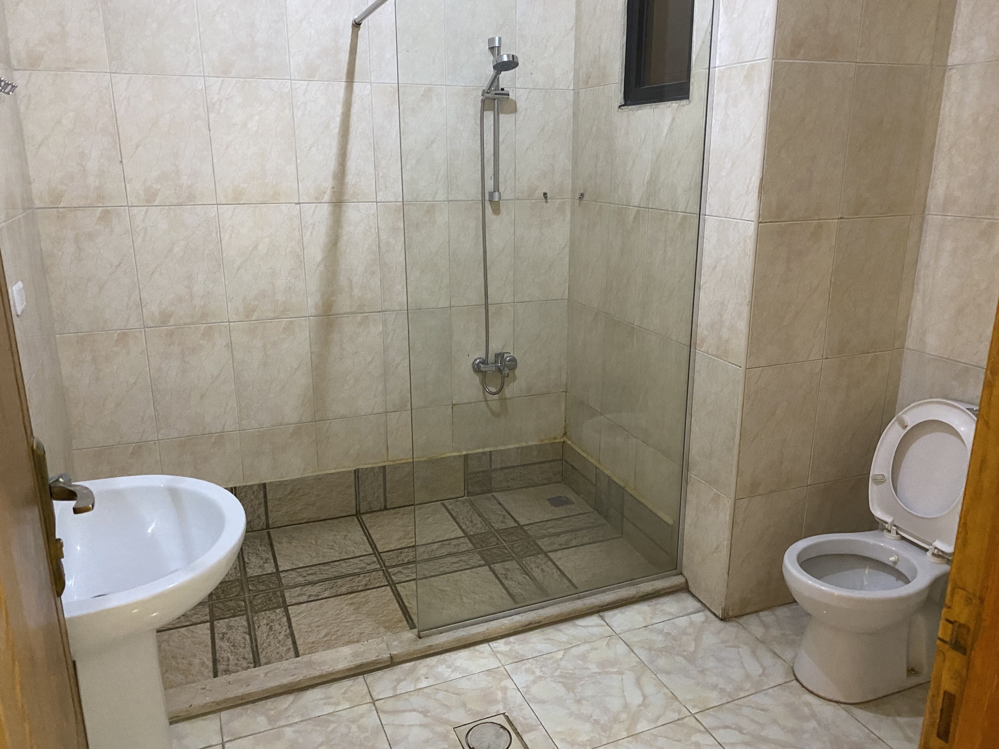 A bathroom with a shower, toilet, and sink.