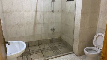 A bathroom with a shower, toilet, and sink.