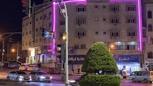 A hotel with a prominent sign, multiple windows, and a well-lit facade. - Sara Crown Hotel (Irbid)