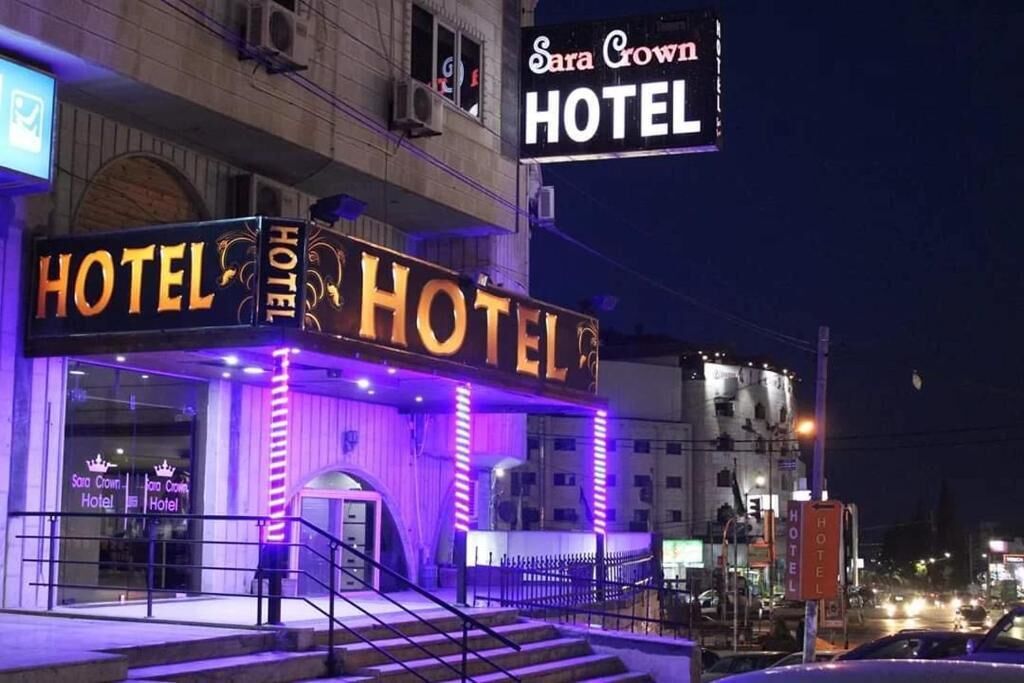 The Sara Crown Hotel with illuminated signage and a visible entrance.
