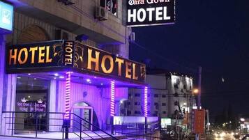 The Sara Crown Hotel with illuminated signage and a visible entrance.