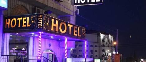 The Sara Crown Hotel with illuminated signage and a visible entrance.