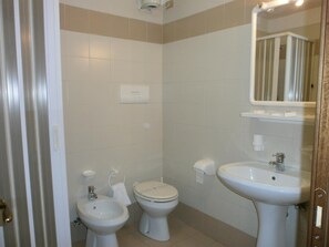 A bathroom with two toilets, a bidet, a sink, and a mirror. - Casa Montana S. Maddalena di Canossa (San Vito di Cadore)